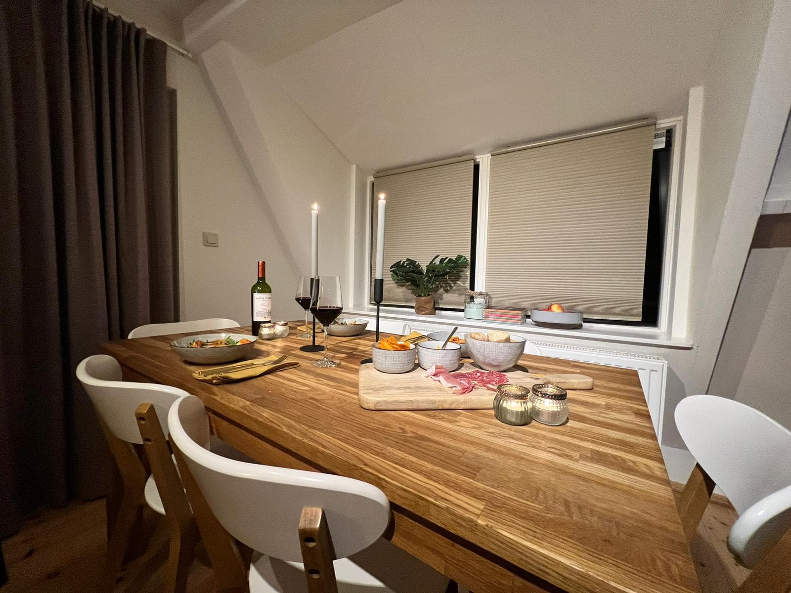 De eettafel met kaarsen en een snijplank met charcuterie