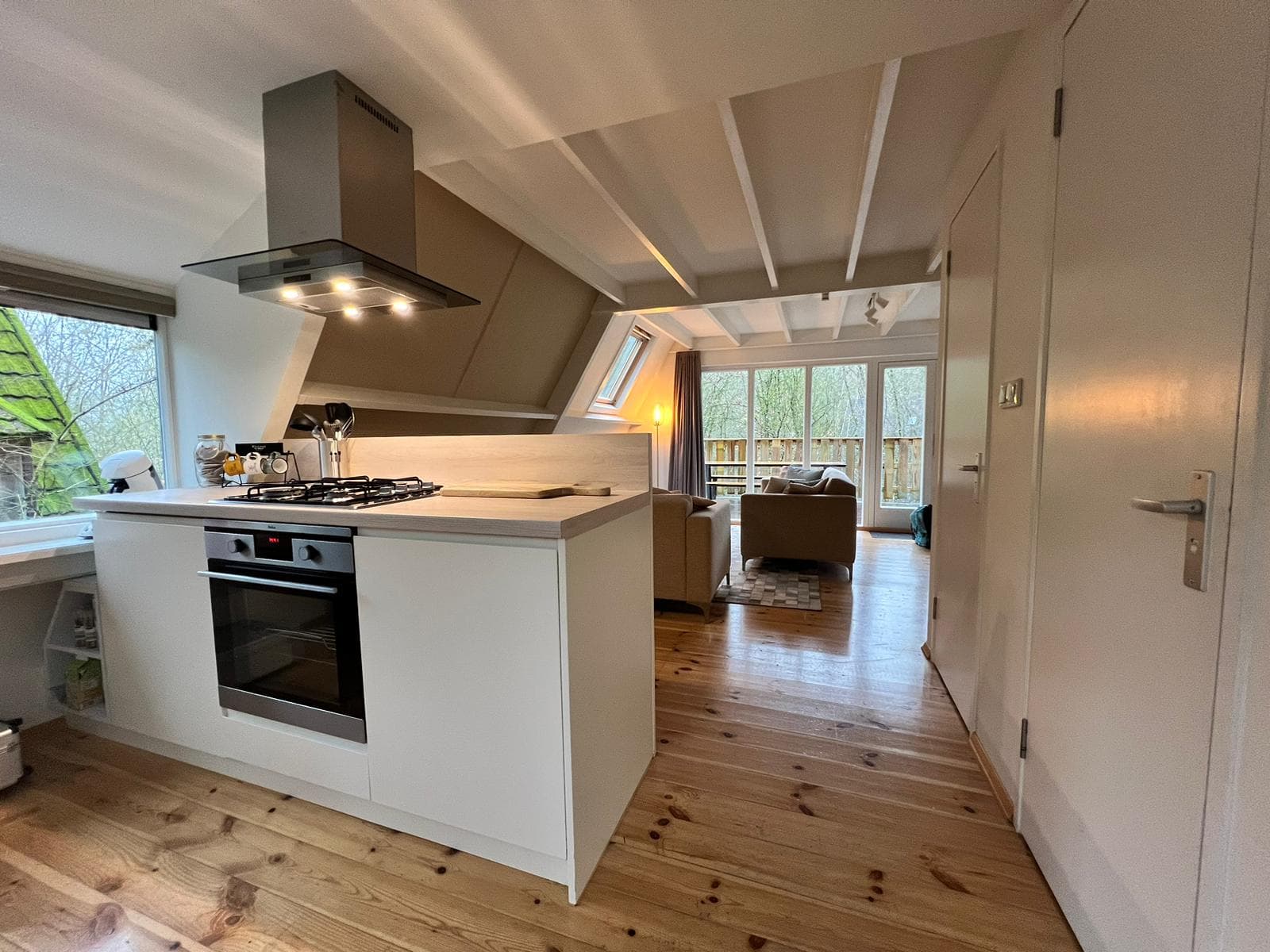 Een verlichte keuken met uitzicht op de living
