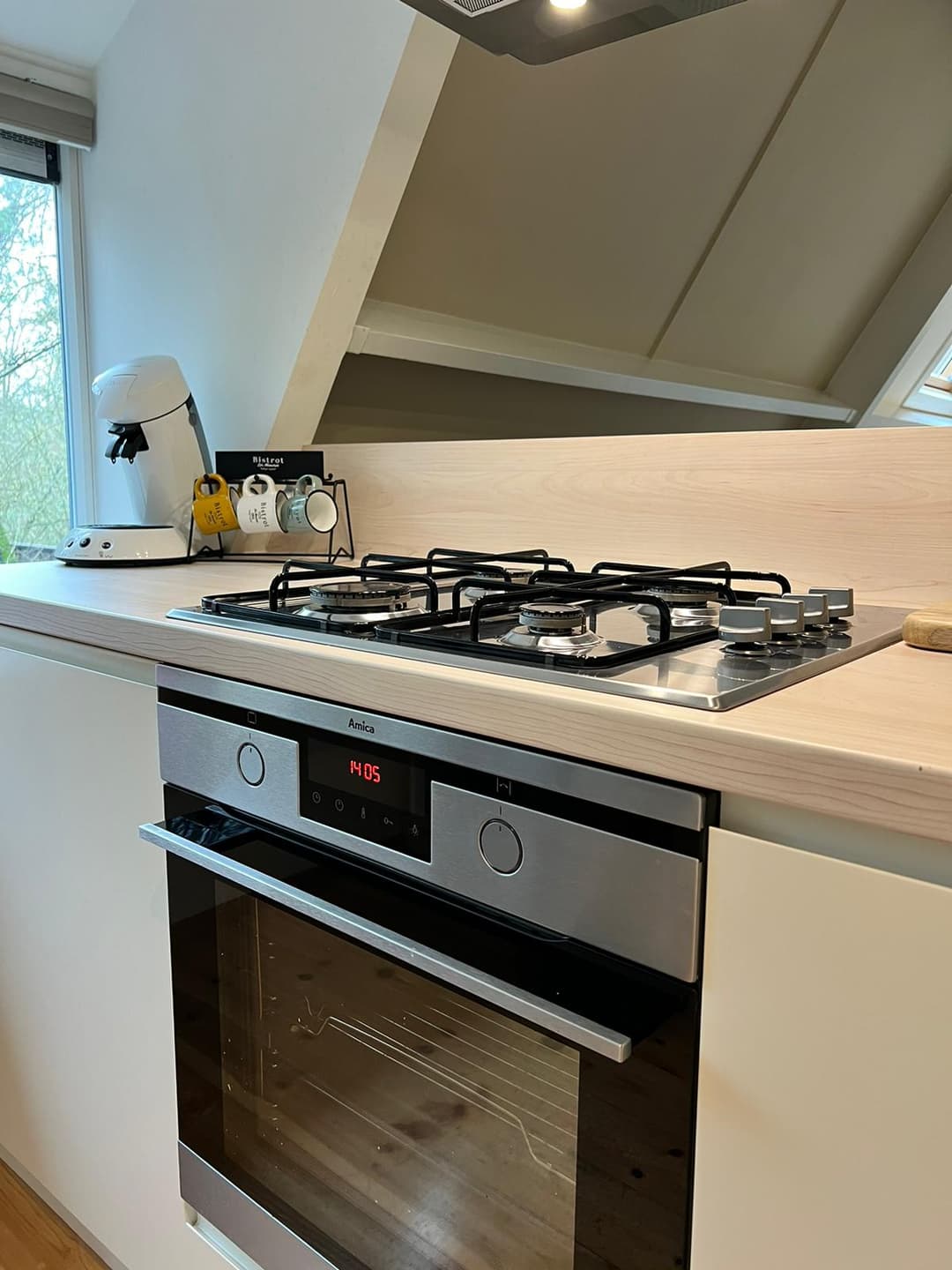 De keuken met gasfornuis een koffiezet apparaat met senseo apparaat en een Amica oven